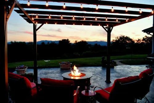 Professional low-voltage landscape lighting illuminating a patio at dusk